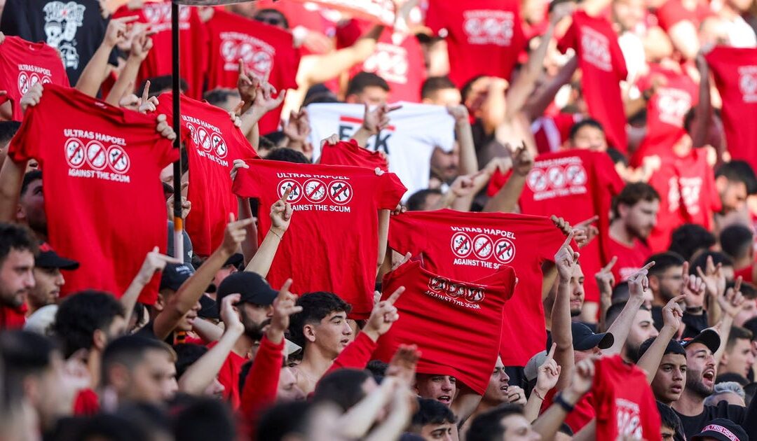 Thousands of Israeli soccer fans wear anti-police shirts at Tel Aviv match after High Court ruling